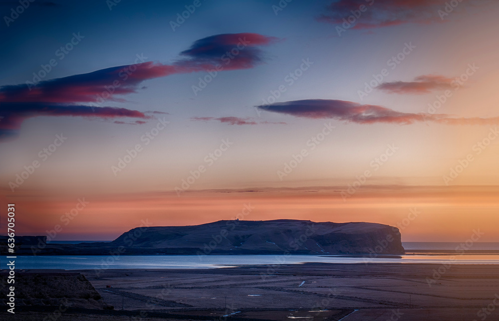Fototapeta premium Photo of a beautiful sunset over a serene Icelandic body of water
