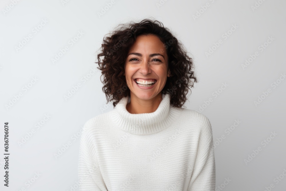 Medium shot portrait of a Brazilian woman in her 40s in a white background wearing a cozy sweater Medium shot portrait of a Brazilian woman in her 40s in a white background wearing a cozy sweater