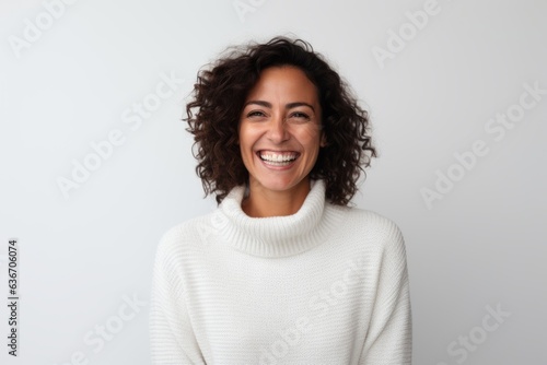 Medium shot portrait of a Brazilian woman in her 40s in a white background wearing a cozy sweater