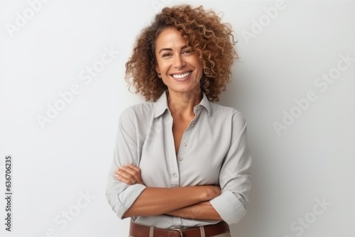 Medium shot portrait of a Brazilian woman in her 40s in a white background wearing a smart pair of trousers