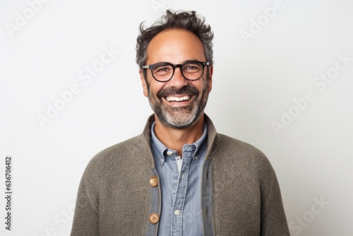 Lifestyle portrait of a Brazilian man in his 40s in a white background wearing a chic cardigan © Anne-Marie Albrecht