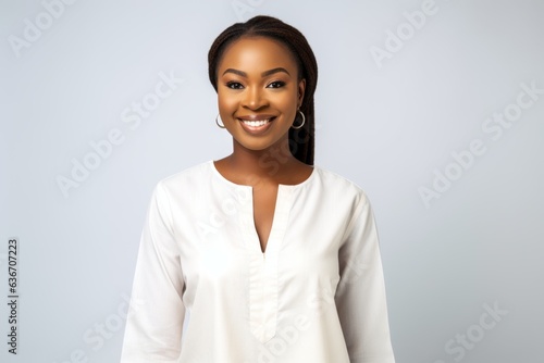 Lifestyle portrait of a Nigerian woman in her 20s in a white background wearing a simple tunic