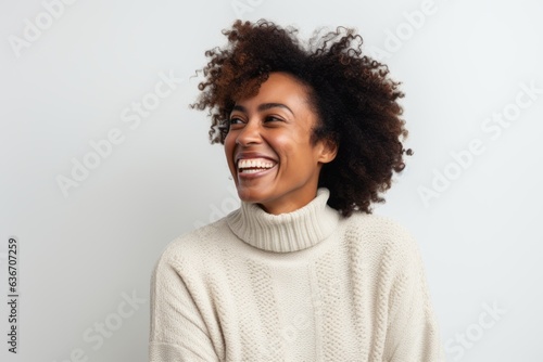 Lifestyle portrait of a Nigerian woman in her 30s in a white background wearing a cozy sweater