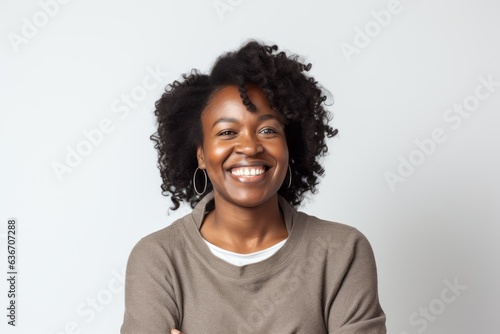 Group portrait of a Nigerian woman in her 30s in a white background wearing a cozy sweater