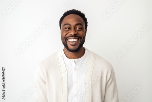 Medium shot portrait of a Nigerian man in his 30s in a white background wearing a chic cardigan