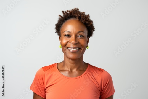 Lifestyle portrait of a Nigerian woman in her 40s in a white background wearing knee-length shorts