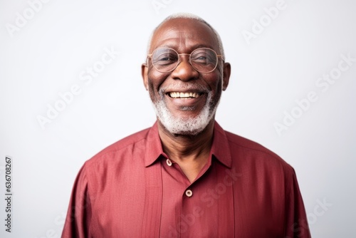 Lifestyle portrait of a Nigerian man in his 60s in a white background wearing a chic cardigan
