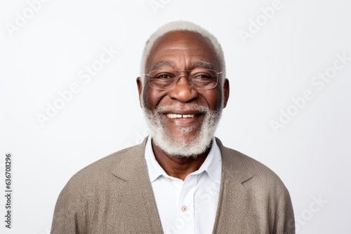 Medium shot portrait of a Nigerian man in his 70s in a white background wearing a chic cardigan