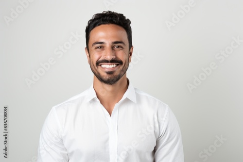 Lifestyle portrait of a Saudi Arabian man in his 30s in a white background wearing a chic cardigan