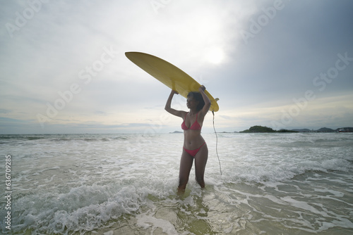 Front view of African american woman with surfboard at beach in the sunshine © FotoArtist