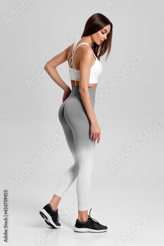 Athletic girl on the gray background. Fitness woman
