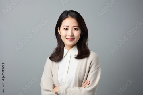 Young asian businesswoman smile and looking at camera on gray background