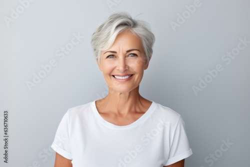 Portrait of happy senior woman looking at camera isolated on grey background