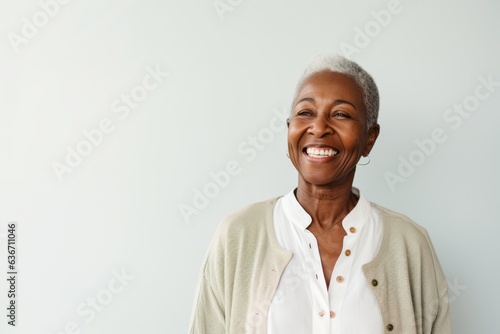 Portrait of a smiling senior woman standing against white background and looking away