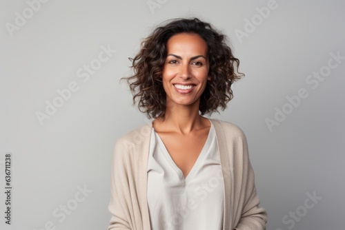 Portrait of a smiling businesswoman looking at camera over gray background