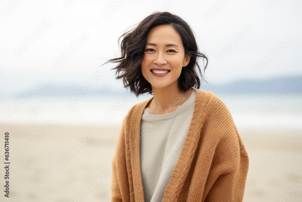 Portrait of a smiling young woman standing on the beach in autumn Portrait of a smiling young woman standing on the beach in autumn