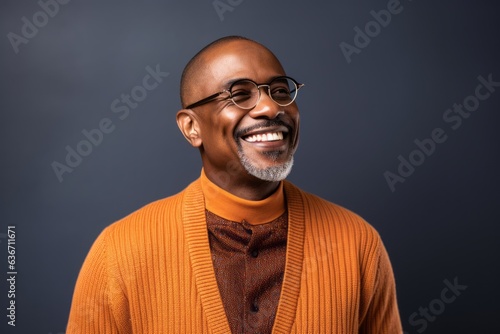 smiling african american man in orange sweater and eyeglasses