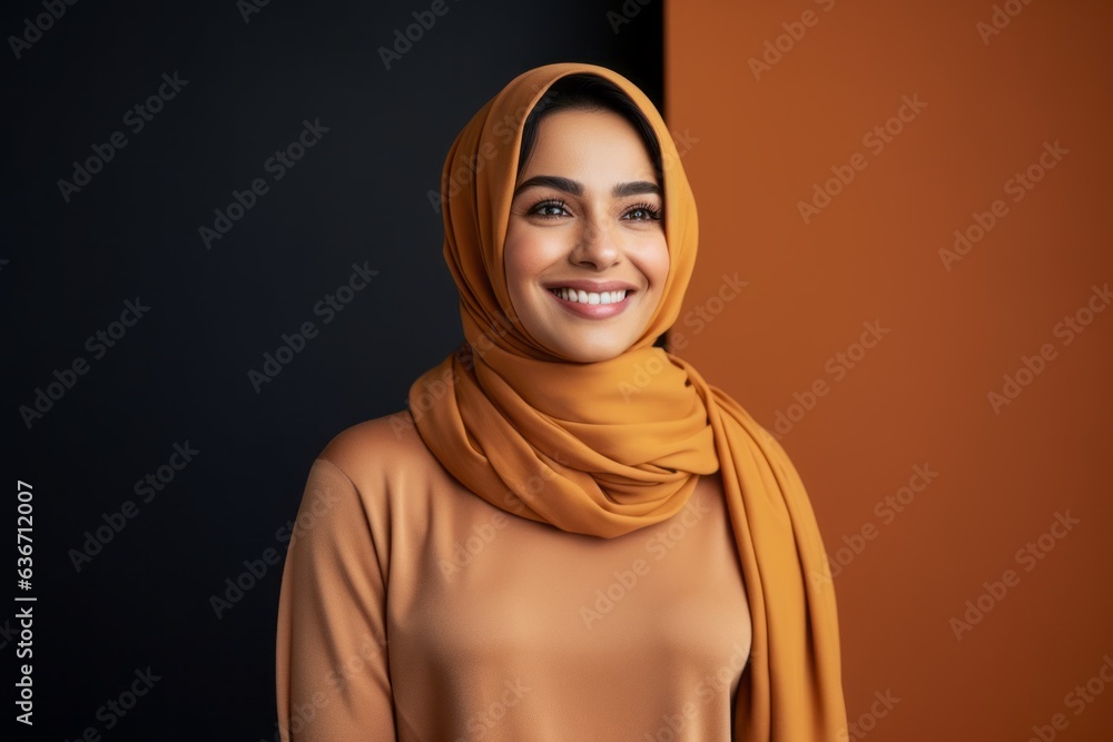smiling muslim woman in hijab looking at camera isolated on black and orange smiling muslim woman in hijab looking at camera isolated on black and orange