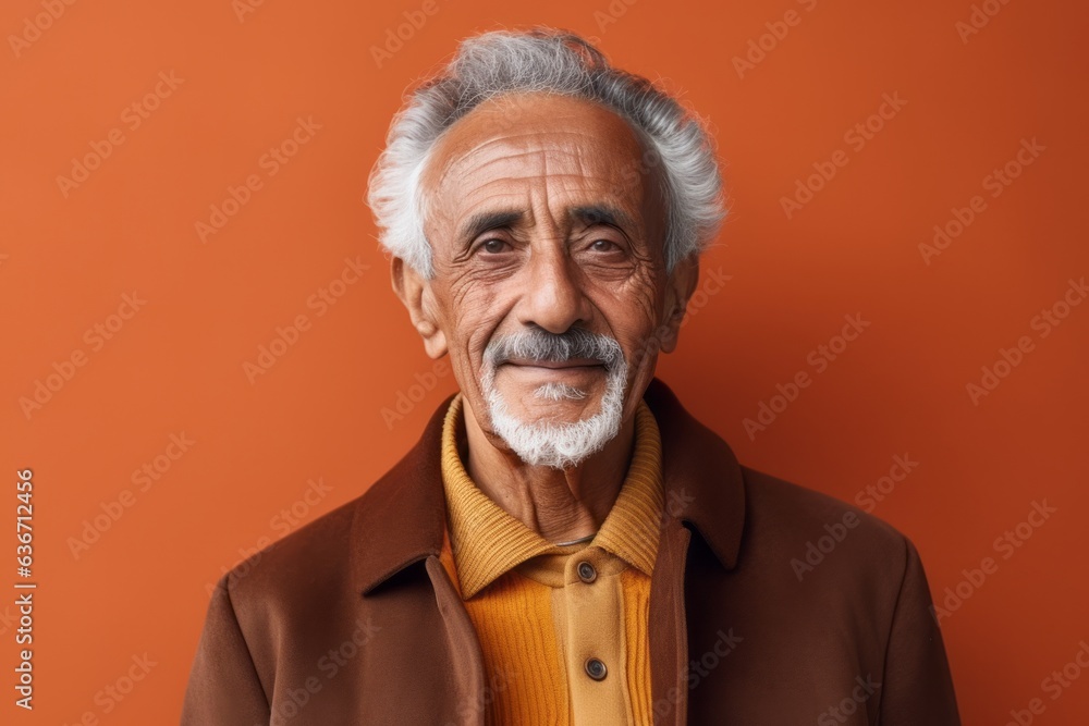 Portrait of a smiling senior Indian man on a orange background. Portrait of a smiling senior Indian man on a orange background.