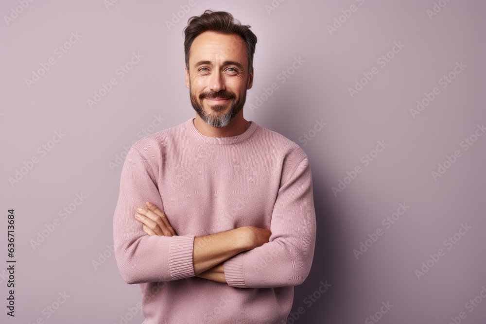 Handsome man looking at camera and smiling while standing against grey background Handsome man looking at camera and smiling while standing against grey background