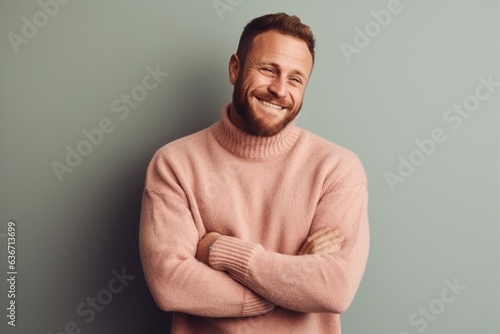 Lifestyle portrait of a Russian man in his 30s in a pastel or soft colors background wearing a cozy sweater