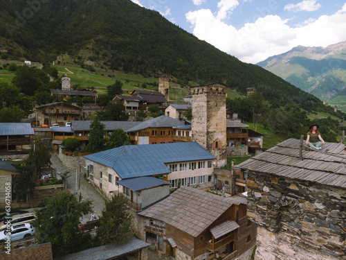 Tourists on the roof of the tower, enjoying the view. Resting Aerial view of Mestia town in Svaneti region of Georgia, located in the Caucasus Mountains. Mestia © Sergey