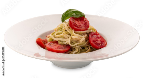 Linguine of two types, white and green, with fresh tomato slices, basil leaves and olive oil in a dish isolated