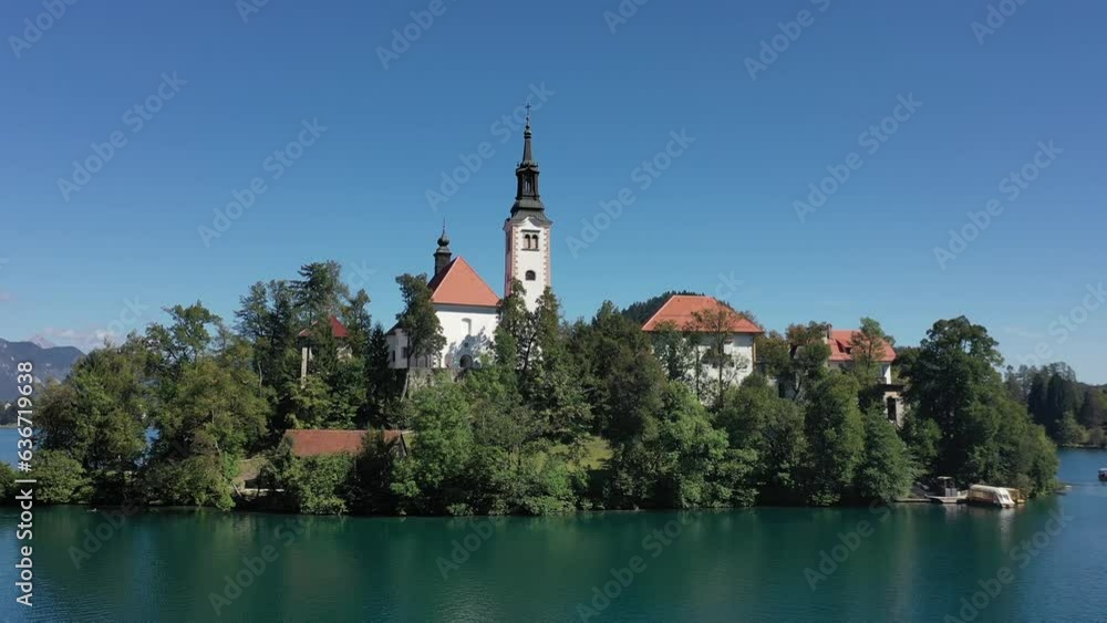 Church of the Assumption of Mary in the center of the lake Bled. Slovenia. Aerial. Summer. Drone video. Flying around small island on Bled Lake. Blue water and forest around. Church of the Assumption of Mary in the center of the lake Bled. Slovenia. Aerial. Summer. Drone video. Flying around small island on Bled Lake. Blue water and forest around.