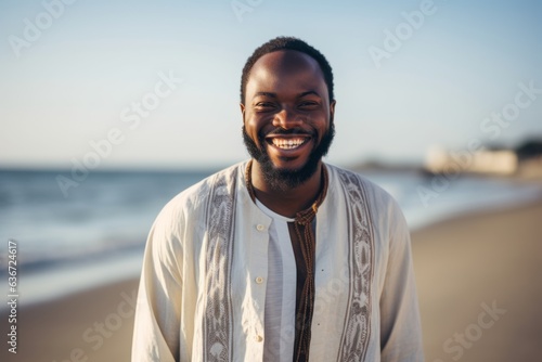Lifestyle portrait of a Nigerian man in his 30s in a beach background wearing a chic cardigan