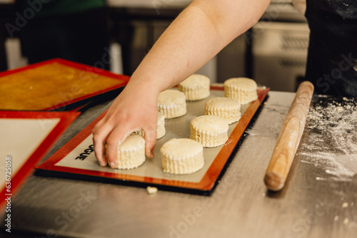 Baker places freshly cut scone dough on tray