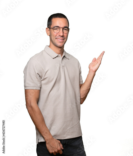 Amazed young man making a gesture of welcome