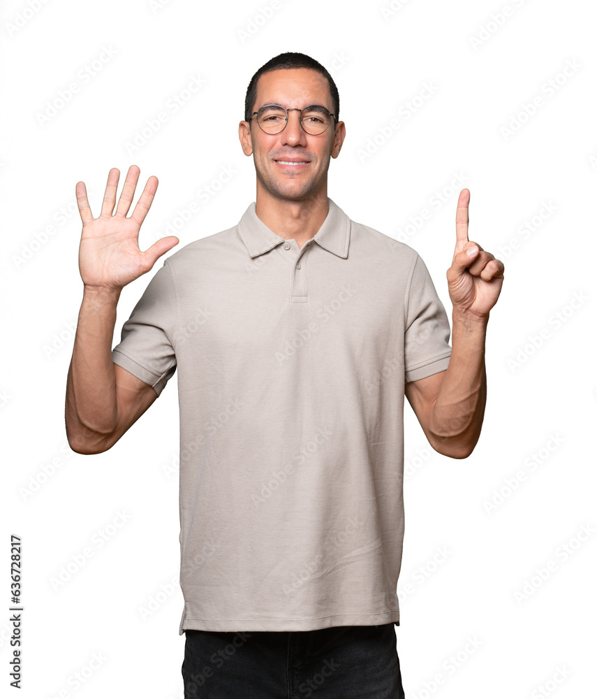 Happy young man doing a number six gesture with his hands Happy young man doing a number six gesture with his hands