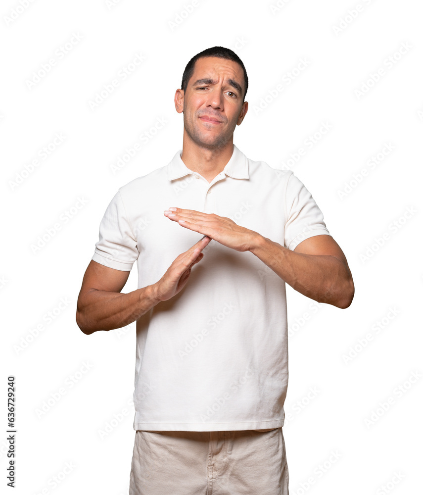 Stressed young man making a time out gesture with his hands Stressed young man making a time out gesture with his hands