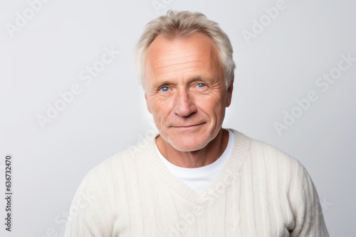 Portrait of mature man with grey hair looking at camera on white background © Hanne Bauer