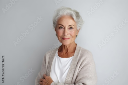 Portrait of a beautiful senior woman looking at camera on gray background