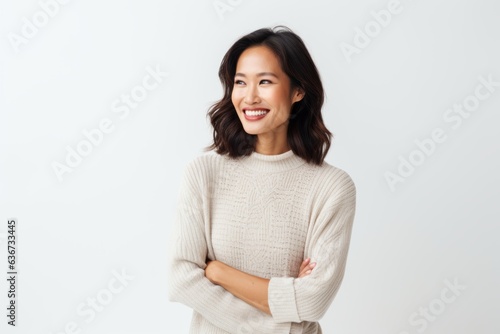 Obraz na płótnie Portrait of a happy young asian woman standing with arms folded over white background w salonie