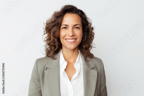 Portrait of a Brazilian woman in her 40s in a white background wearing a classic blazer