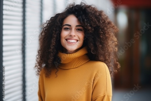 Portrait of a smiling young african american woman in sweater standing outdoors