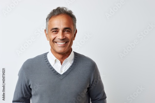 Portrait of handsome mature man smiling at camera while standing against white background © Hanne Bauer