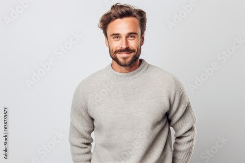 Portrait of a handsome young man smiling at camera over gray background