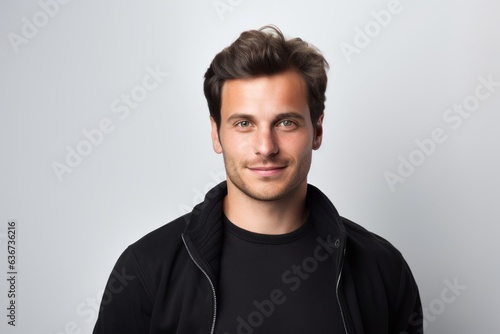 Portrait of handsome young man in black sweatshirt on grey background