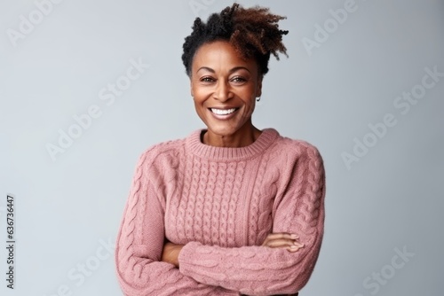 Portrait of a smiling african american woman standing with arms folded isolated over gray background