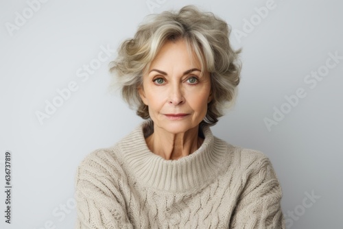 Portrait of a senior woman with grey hair. Grey background.
