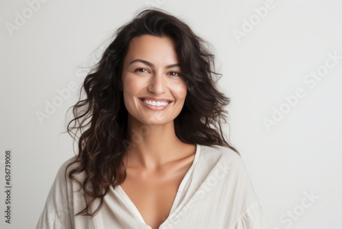 Portrait of beautiful young woman with long wavy hair smiling at camera