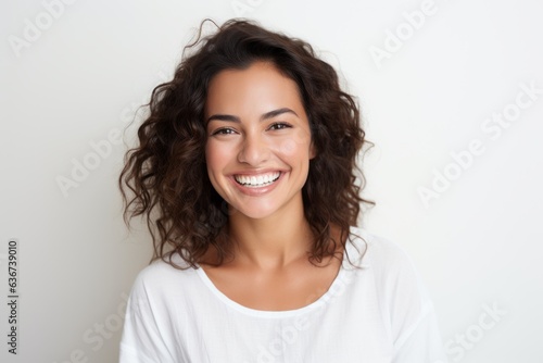 Portrait of a happy young woman smiling and looking at camera over white background