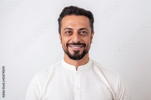 Medium shot portrait of a Saudi Arabian man in his 40s in a white background wearing a chic cardigan