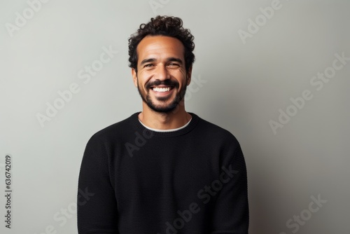 Portrait of a happy young man smiling at camera against grey background