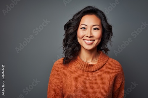 Portrait of a Chinese woman in her 40s in an abstract background wearing a cozy sweater