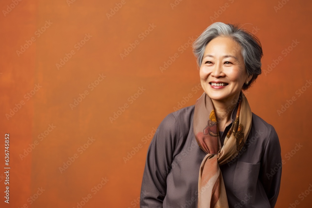Portrait of a Chinese woman in her 60s in an abstract background wearing a smart pair of trousers Portrait of a Chinese woman in her 60s in an abstract background wearing a smart pair of trousers