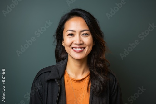 Portrait of a Indonesian woman in her 30s in an abstract background wearing a chic cardigan